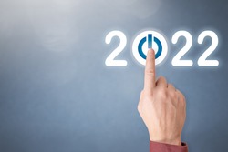 Finger pressing blue start 2022 button on virtual interface on gray background with copy space for text. Concept of new year. Businessman pressing 2022 start up business. Beginning of New Year 2022