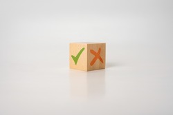 Tick mark and cross mark x on wooden cubes. pros and cons concept. Wooden cube with image of pros versus cons. Concept of positive or negative decision making or choice of approval or rejection.