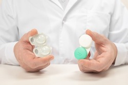 Different types of Contact Lenses. Doctor Ophthalmologist holds and Comparing one-day contact lenses and reusable contact lenses. cropped view of man choosing ways of vision correction