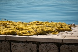 fishing nets dry on shore. Fishing net near dock. Stacked yellow coloured fishing nets. fishing nets dry on shore near dock. Yellow coloured fishingnets