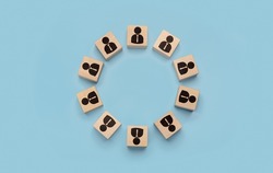 round table, business meeting concept. businessmen icons on wooden cubes arranged in circle on blue background. discussion of important issues, round table talks