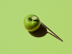 apple and angled mirror on green background. horizontal. dental concept