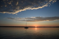 A sailboat anchored off South Twin Island in Lake Superior during sunset at the Apostle Islands National Lakeshore.