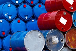 Old chemical barrels. Blue and red oil drum. Steel and plastic oil tank. Toxic waste warehouse. Hazard chemical barrel with warning label. Industrial waste in drum. Hazard waste storage in factory. 