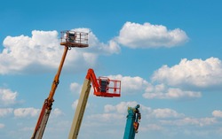 Articulated boom lift. Aerial platform lift. Telescopic boom lift against blue sky. Mobile construction crane for rent and sale. Maintenance and repair hydraulic boom lift service. Crane dealership. 