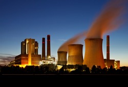 Brown coal power station with night blue sky and steam.
