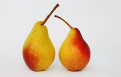 A pair of red-yellow juicy tasty pears on a white paper background.
