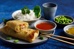 Homemade spring rolls with rice and sour sweet sauce and curry on the side.