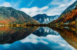 Panoramic view of the mountain village in the Austrian Alps. Autumn Landscape. Hallstatt, Austria. Blue sky and mountains. Beautiful and cozy town. Postcard concept. Hallstatter lake with reflections.