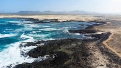 Aerial view of Caleta del Marrajo, a windy bay on the north coast of Fuerteventura in the Canary Islands, Spain - Desertic landscape near the Atlantic Ocean