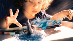 Concept of toddler imagination, dream painting a dolphin. Virtual reality or augmented reality study. Dreamy picture of kids imagination and fantasy without boundaries. Limitless possibilities.