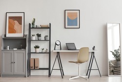 Background of minimal home office workplace in modern apartment decorated by plants and abstract art, copy space