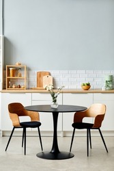 Minimal background image of elegant black table with two chairs in modern kitchen interior, copy space