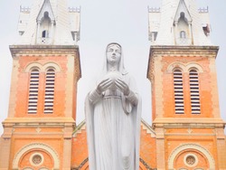 Portrait picture of statue of Blessed Virgin Mary, Jesus's mother in front of old vintage brick church, the tourist attraction in Hanoi, Vietnam