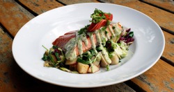 Smoked salmon fillet with vegetables: parsnip, radish, spinach and celery. Gourmet food served in a fancy restaurant. 