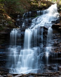 Large multi-tiered waterfall with silky cascades in Rickets Glen Pennsylvania