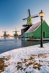 snow covered windmill village in the Zaanse Schans Netherlands, historical wooden windmills in winter Zaanse Schans Holland during winter