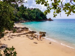 Banana Beach, Phuket, Thailand,A beautiful tropical beach with palm trees at Phuket island, Thailand, Located in Choeng Thale, Thalang, couple man and woman mid age on vacation in Thailand