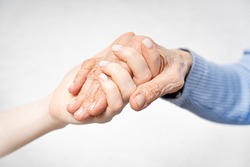 Young hands hold old hands. Help for the elderly concept. 