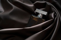 Men's perfume bottle in satin cloth waves draperies.