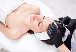 Botulinum toxin injection therapy to eliminate mimic wrinkles at forehead.