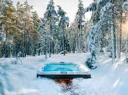Hot tub in the middle of a beautiful winter forest. Nothing is more relaxing than a soak in a hot tub on a cold winter's day.