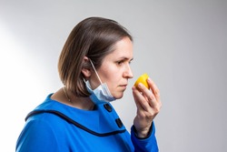 Anosmia or smell blindness, loss of the ability to smell, one of the possible symptoms of covid-19, infectious disease caused by corona virus. Man Trying to Sense Smell of a Lemon, side view.