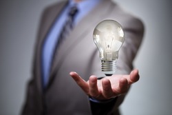 Businessman with illuminated light bulb concept for idea, innovation and inspiration