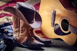 Country music festival live concert with acoustic guitar, antique american flag, cowboy hat and boots