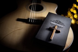 Holy Bible with acoustic guitar and religious crucifix cross, gospel music concept