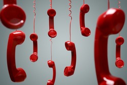 Red telephone receiver hanging over gray background concept for on the phone, on hold or contact us