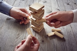 Planning, risk and team strategy in business, businessman gambling placing wooden block on a tower