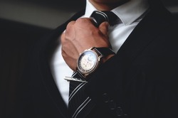 Men's watches. An accessory for men. A man in a suit on a black background.