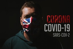 man wearing mask with UK flag for protection of corona virus covid-19 SARS-CoV-2