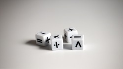 Four white dice with mathematical math symbols.