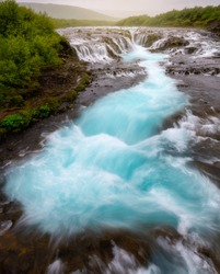 Famous Bruarfoss waterfall with vortex blue water in foreground. Water is of turquoise colour and beautiful cascades
/ Landmark of Iceland.