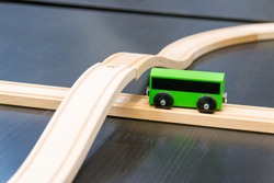 Green bus. Wooden viaduct, ring. Child's toy.
