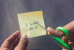 Hands cutting letter T with scissors with written text i can't do it. Business concept for determination Success Challenge self believe Motivation and aspirations to achieve results Aim goal.