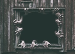 Hands rising out from the old window ancient house, Halloween concept.