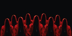 Group of mystery people in a red hooded cloaks. Isolated on black. Unrecognizable person. Hiding face in shadow. Ghostly figure. Sectarians. Conspiracy concept.