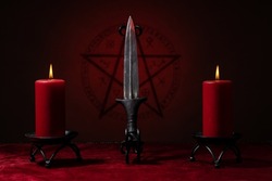 Ritual blade, pentagram symbol and candles. Black magic ritual or spell with occult and esoteric symbols. 