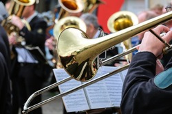 Trombone choir gives concert in the open air – close up of the front trumpet player with selective focus 
