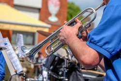 Close-up of a musician plays the trumpet in a big band at a public concert outdoors- selective focus