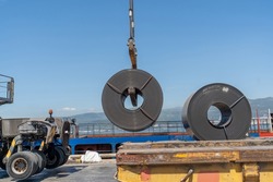 30 ton coils of steel sheet steel are loaded onto ship by crane for shipment