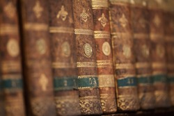 Antique aged books on wooden shelf. Old books background. Shallow depth of field