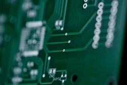 Macro shot of the back side of a circuit board. Close up of a printed green computer circuit board. Circuit board background