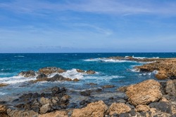 Breathtaking natural beauty as waves meet rugged rock shoreline of Aruba's Caribbean coast.