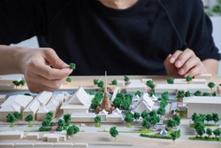 mass model of landscape design or garden design or landscape architecture in waterfront temple area with group of buildings and trees near community,   handmade work, bird's eye view, selective focus