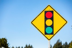 Stop light ahead yellow sign with a traffic signal on it for drivers