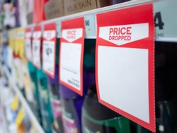 Mock up template of paper tag shows price dropped with blank space for text on supermarket shelf.